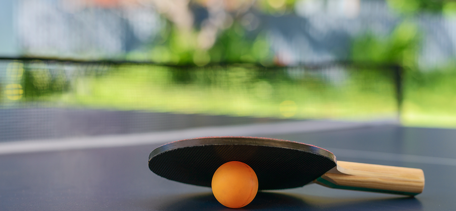 Table tennis paddle and ball outdoors