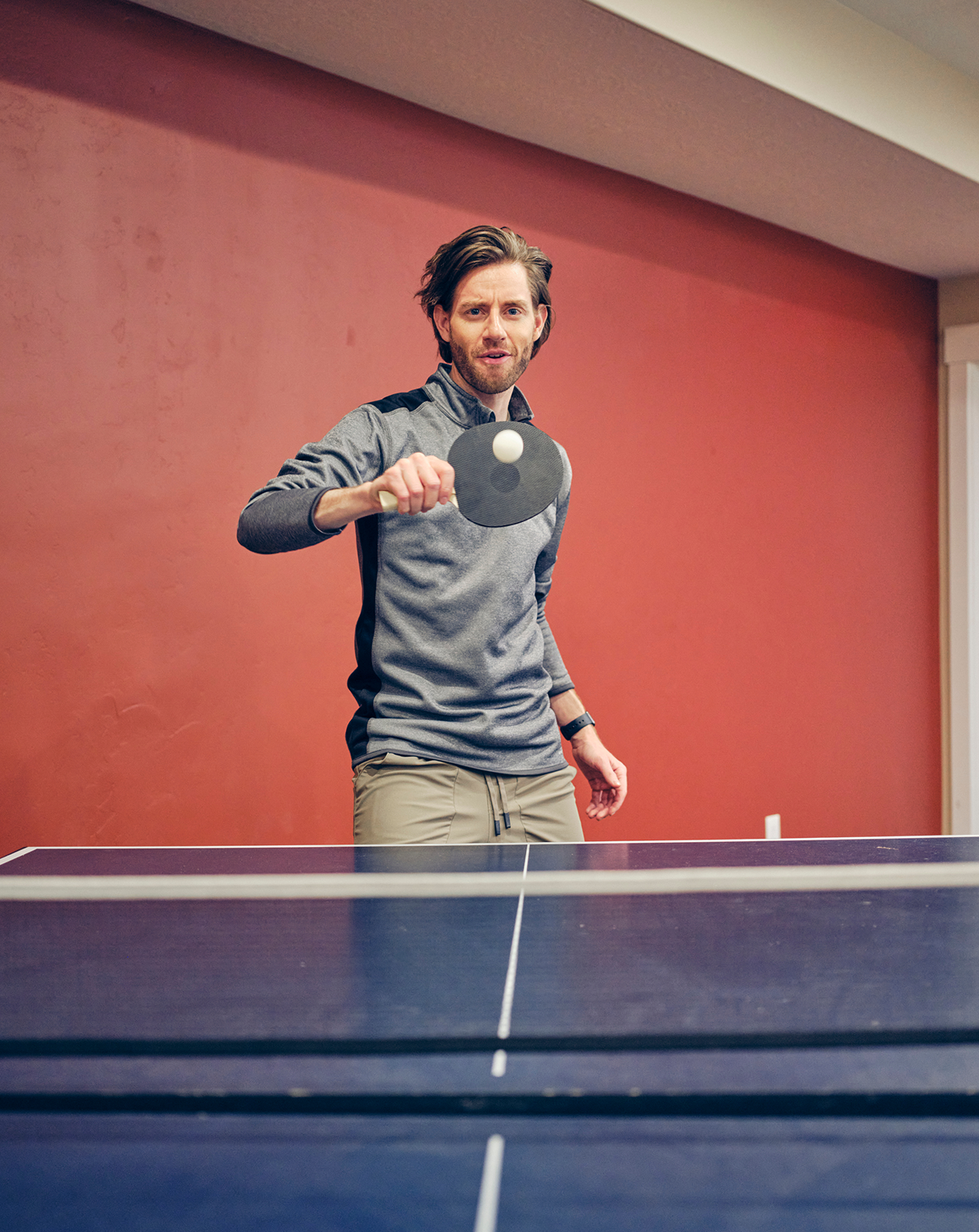 Man playing table tennis indoors