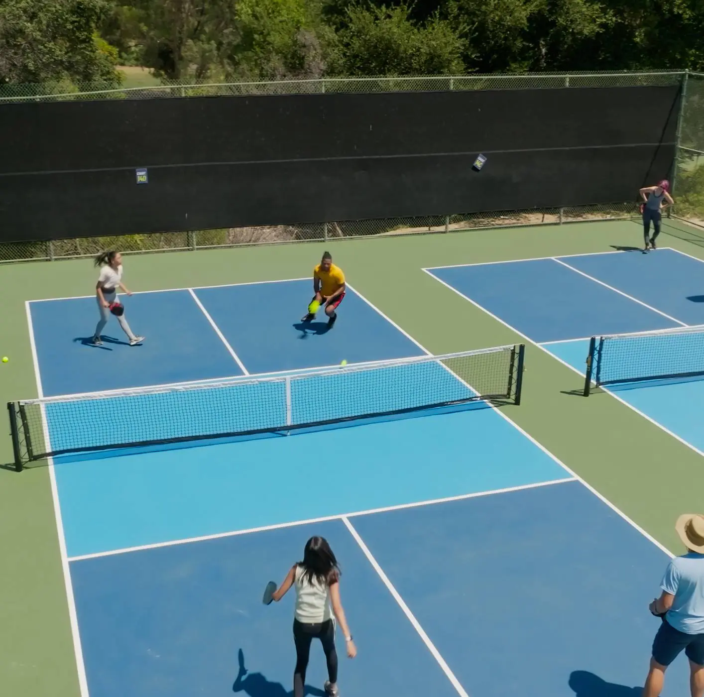 People playing paddle tennis on outdoor court