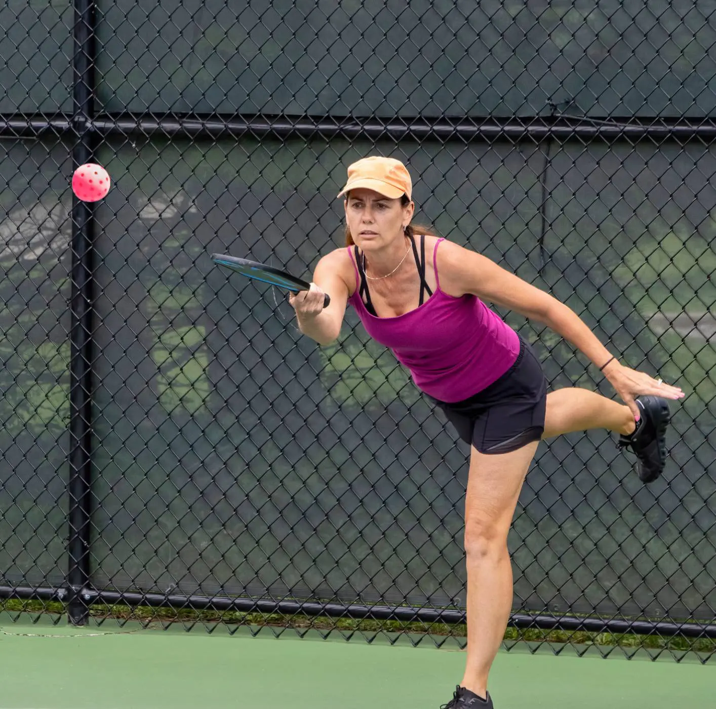 Woman playing pickleball on outdoor court