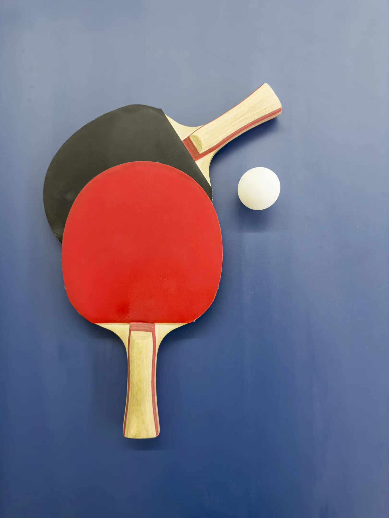 Ping-Pong paddles with ball on table