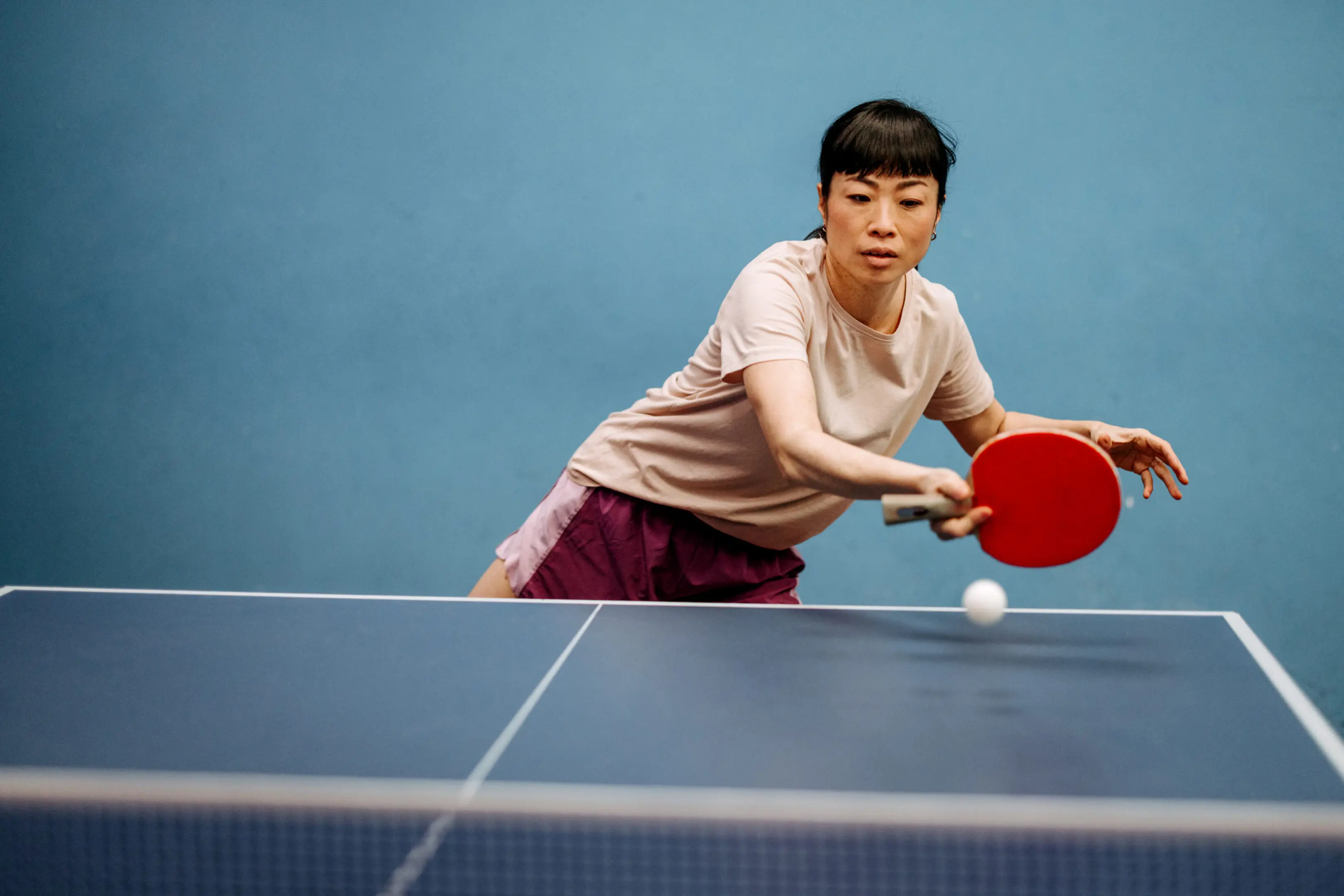 Woman playing table tennis indoors