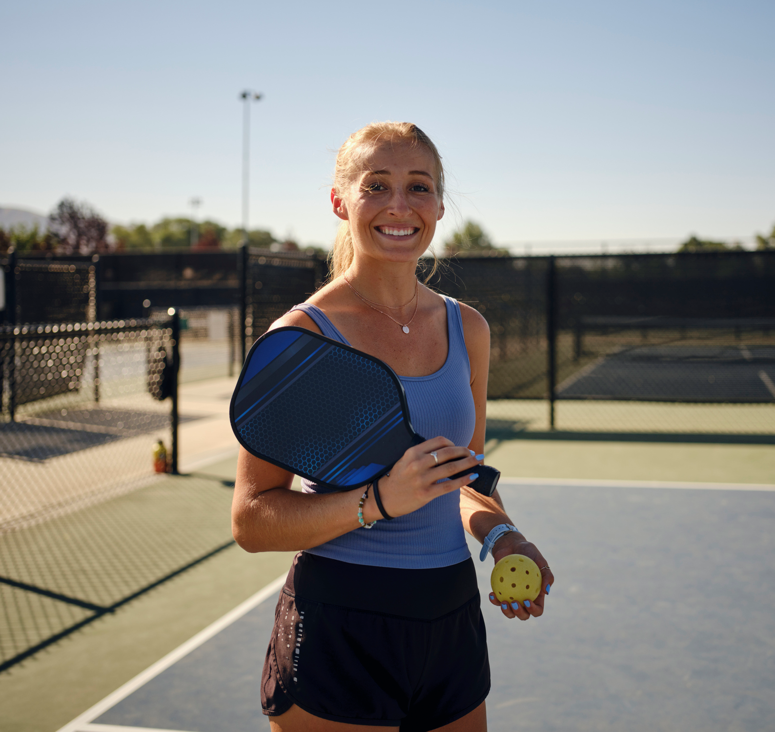 Smiling woman on pickleball court